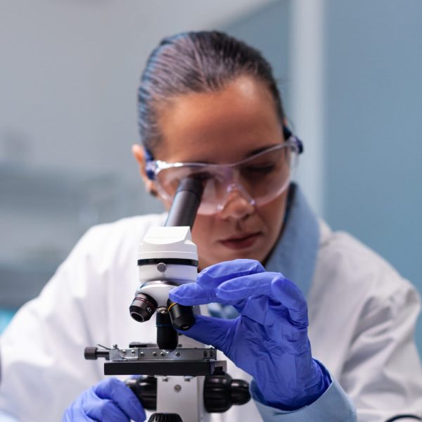 Specialist pharmacist examining bacteriology infection lab test using medical microscope Specialist pharmacist examining bacteriology infection lab test using medical microscope working in pharmacology hospital laboratory. Scientist microbiologist analyzing microbiology expertise